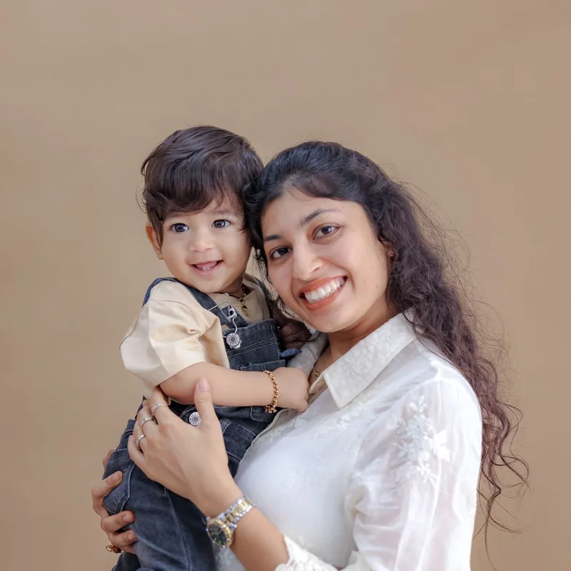 A smiling mother holds her young son.